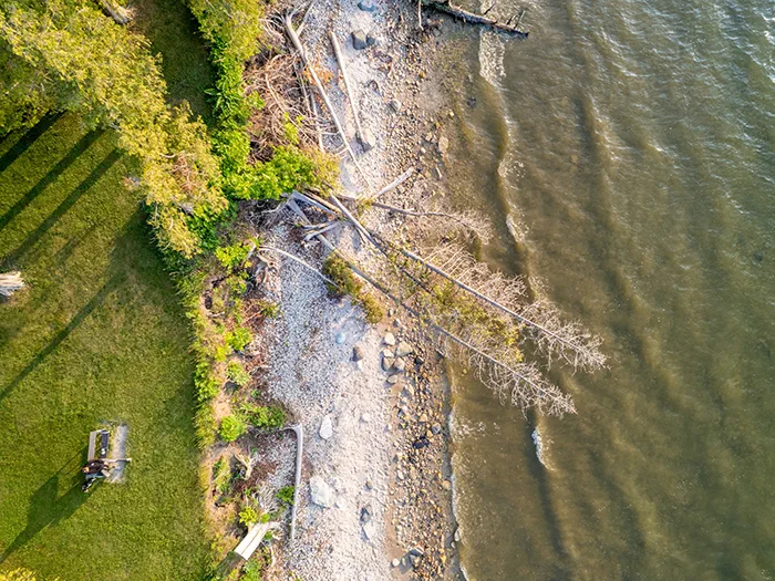 birds eye view of shoreline with visitors sitting on bench