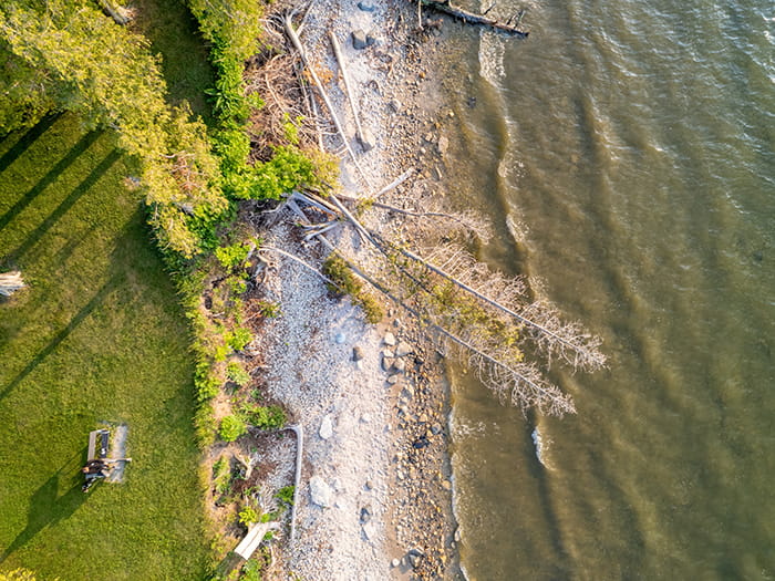 birds eye view of shoreline with visitors sitting on bench