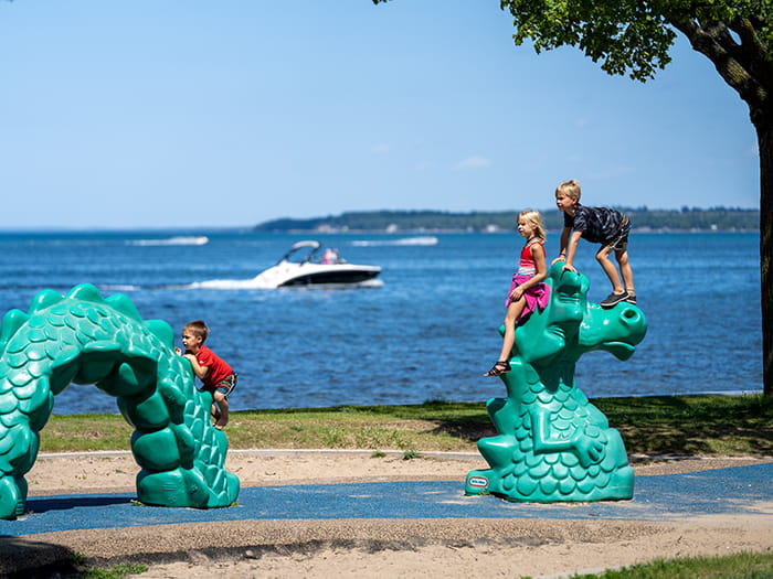 kids playing on play equipment with water in background