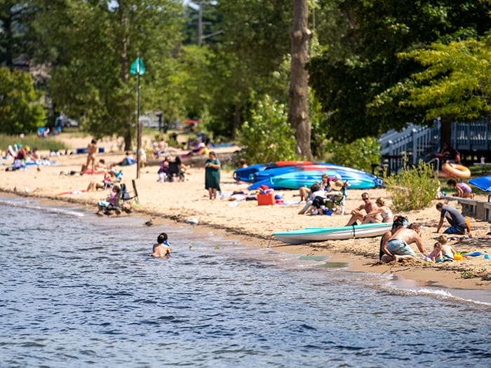 visitors playing and sitting on Lake Michigan beach