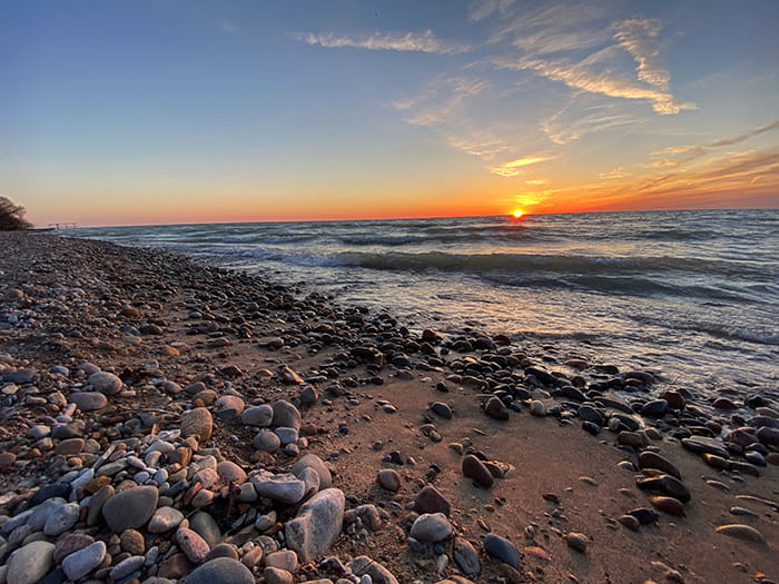 rocky shoreline with sun setting