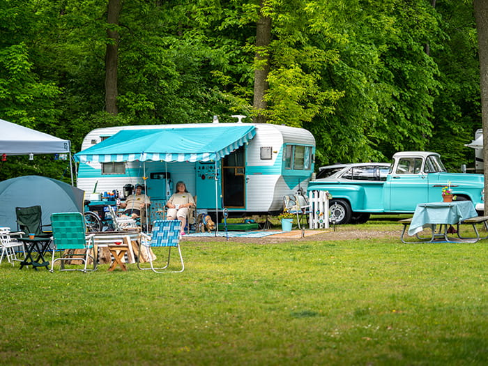Lakeport campground hosts sitting next to their vintage truck and camper