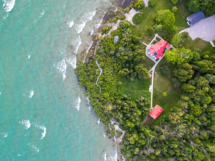 birds eye view of blue water lighthouse and land