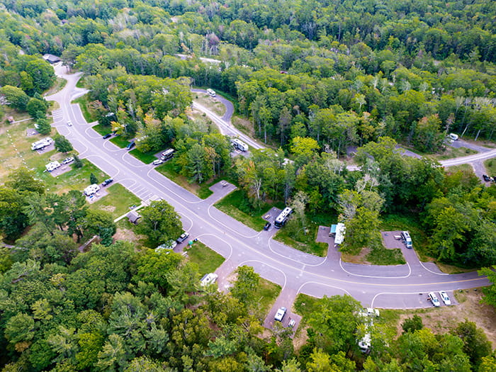 birds eye view of campground sites surrounded by trees