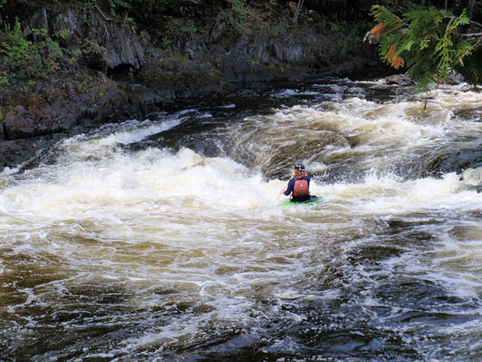 kayaker paddling in rapids