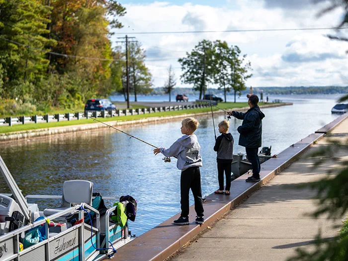 father and two children fishing the canal