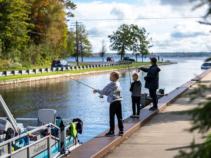 father and two children fishing the canal
