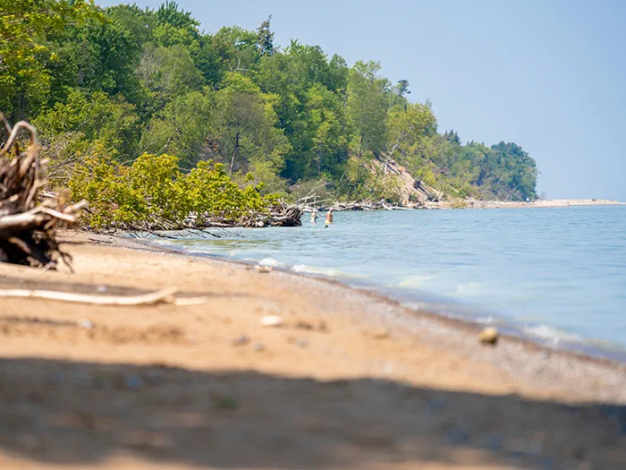 A man and woman wading along the Lake Superior shoreline