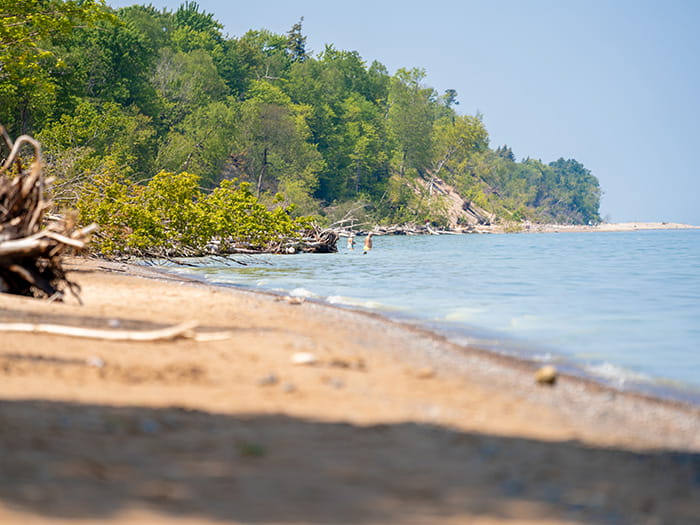 A man and woman wading along the Lake Superior shoreline
