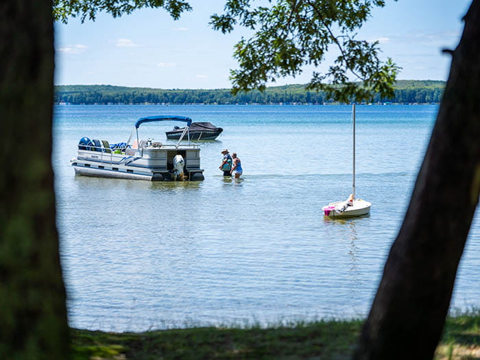 pontoon boat framed by two trees