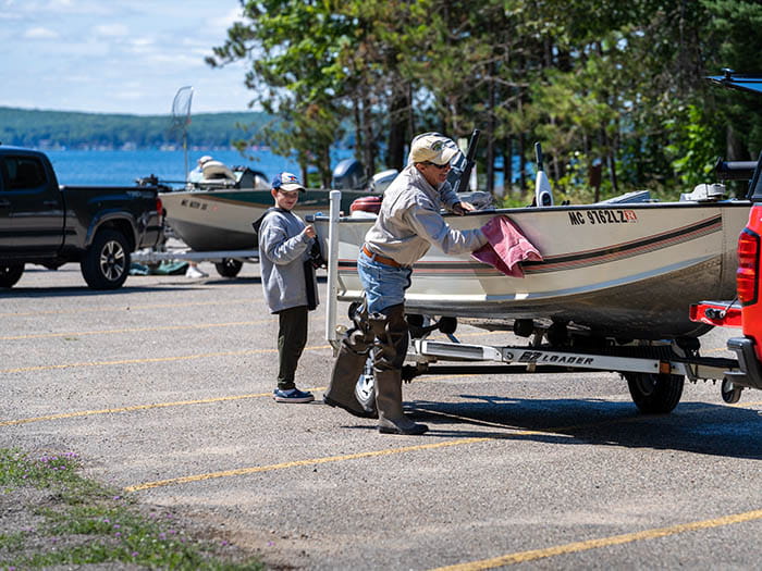 two boaters cleaning boat in parking lot
