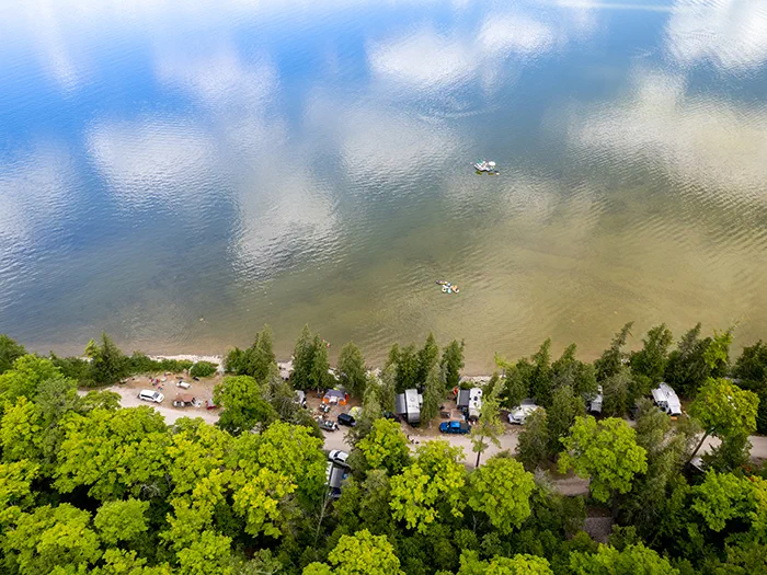 birds eye view of campground with campers along lakeshore