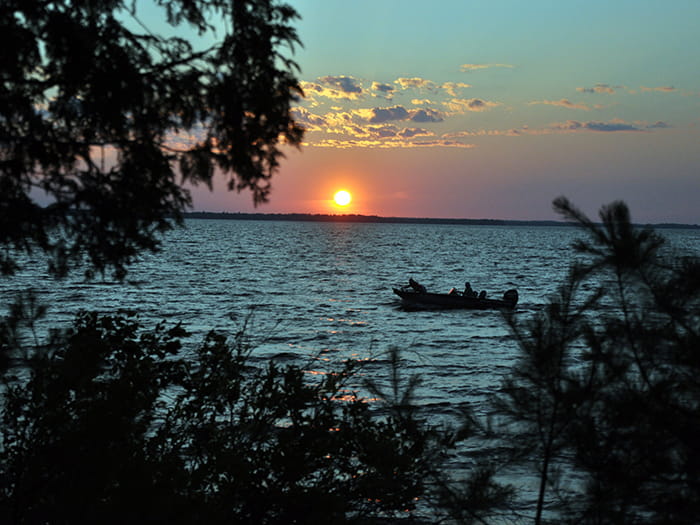 boat on water with sun setting