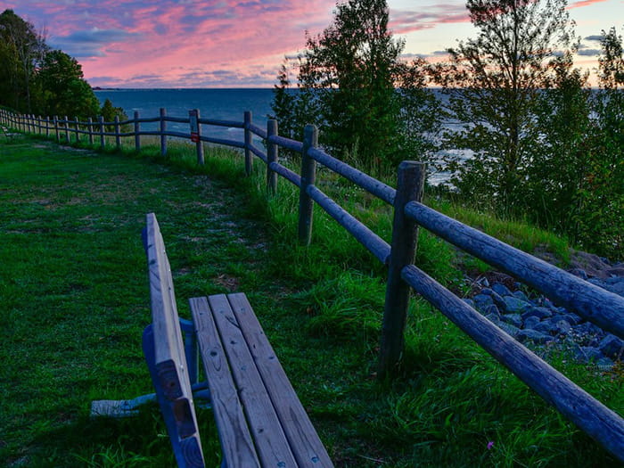 picnic bench next to fence along Lake Michigan