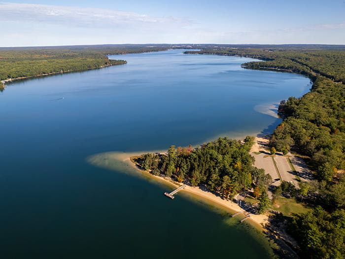 An aerial view of Otsego lake overlooking the boat launch and parking lot