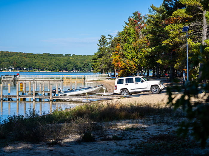 A white SUV launching a boat at the Otsego lake boat launch