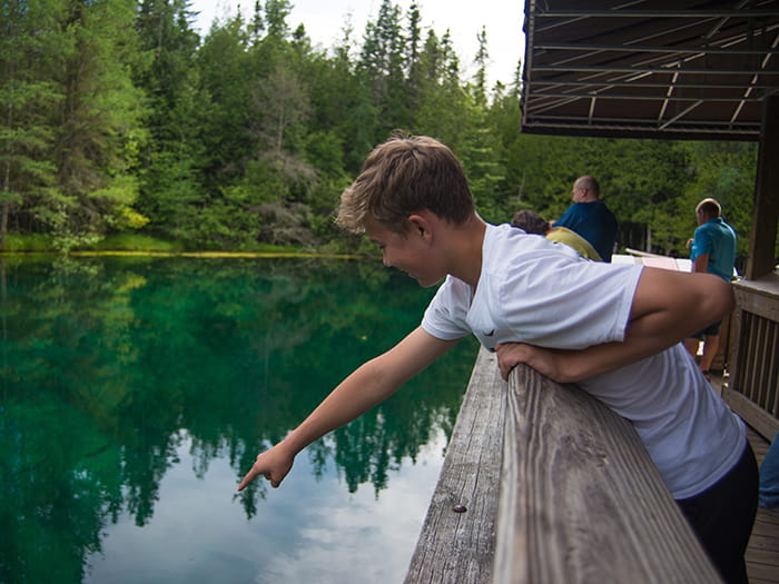 Teen looking down into water from raft