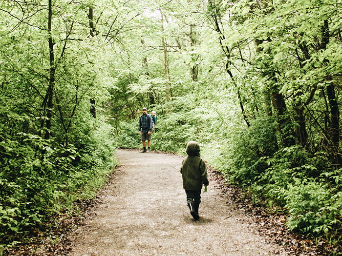 man and children walking hard surface trail