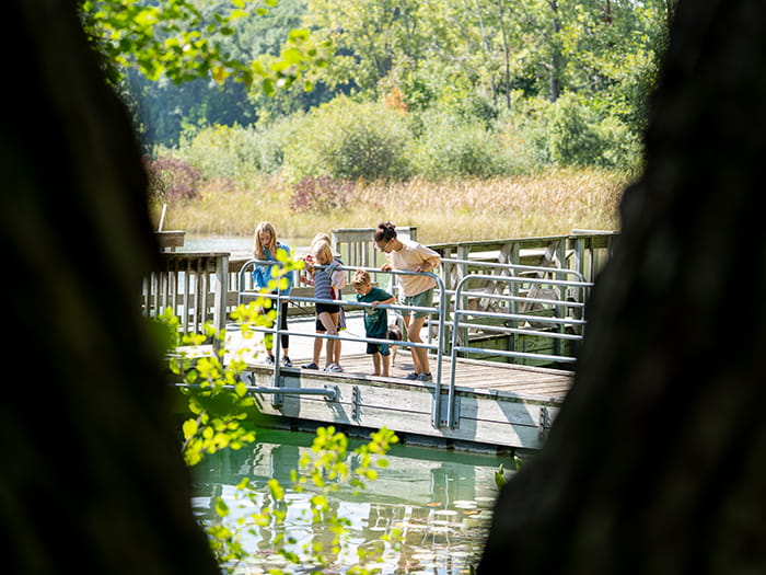 family looking at water from fishing pier