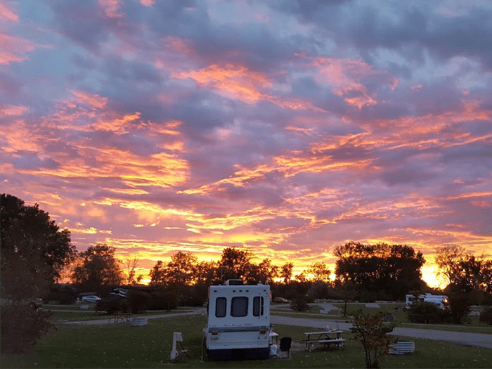 camper sitting in campsite at sunset