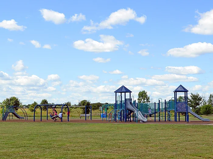 kids playing on playground with blue sky