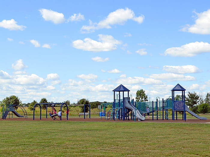 kids playing on playground with blue sky
