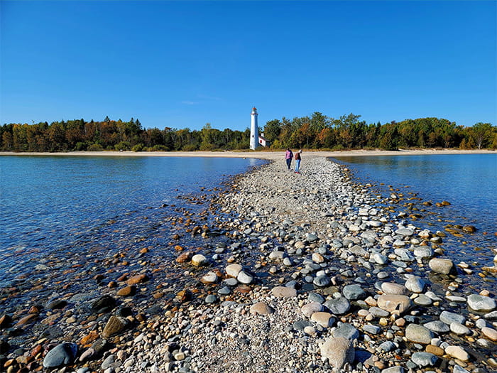 lighthouse in distance with rocks