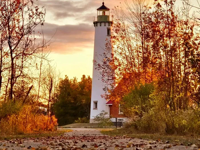Tawas Lighthouse with fall leaves on the ground