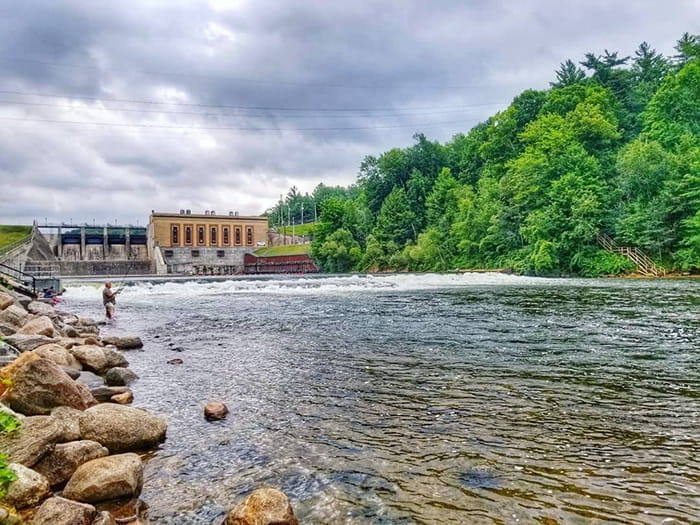 angler in river front of dam