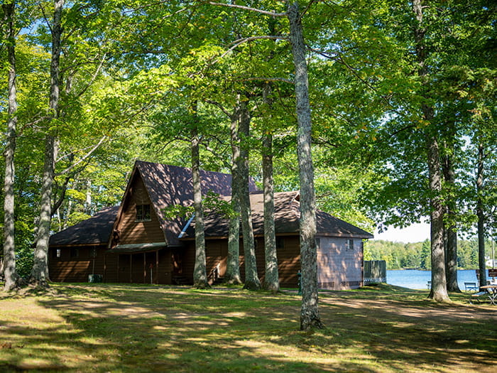 wood sided lodging facility in woods near lake
