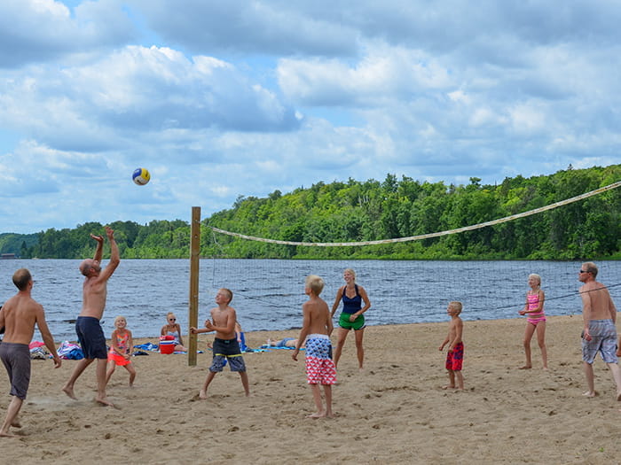 family playing volleyball on beach