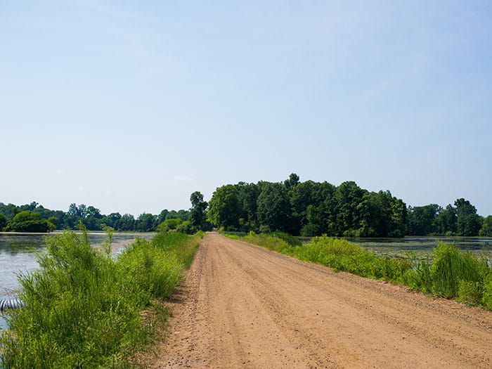 dirt road going between water bodies