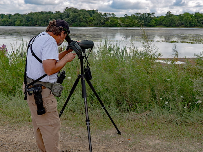 photographer with tripod along lake