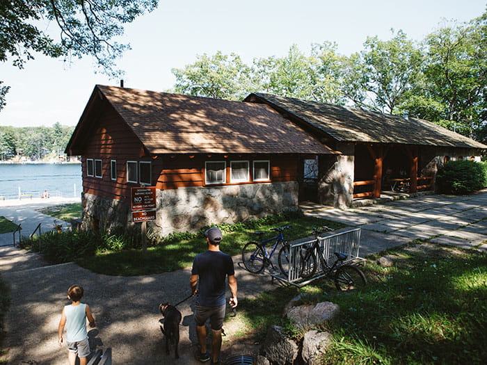 a father and child walking toward the beach house above water