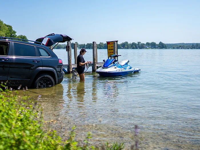 Woman wading in the water to launch a jet ski at Yankee Springs recreation area