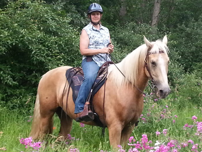 rider posing on horse with flowers