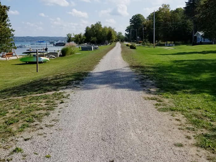 A gravel path alongside a waterfront residential area