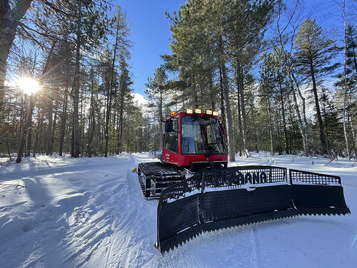 ski trail grooming equipment staged on trail