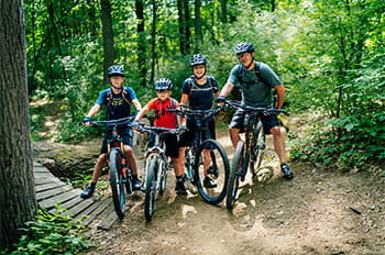 family posing with mountain bikes