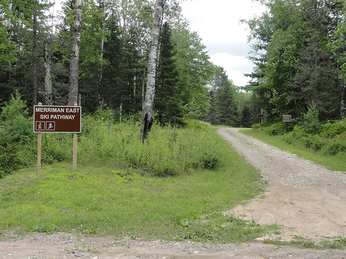 A sign next to a trail identifying the Merriman East Pathway