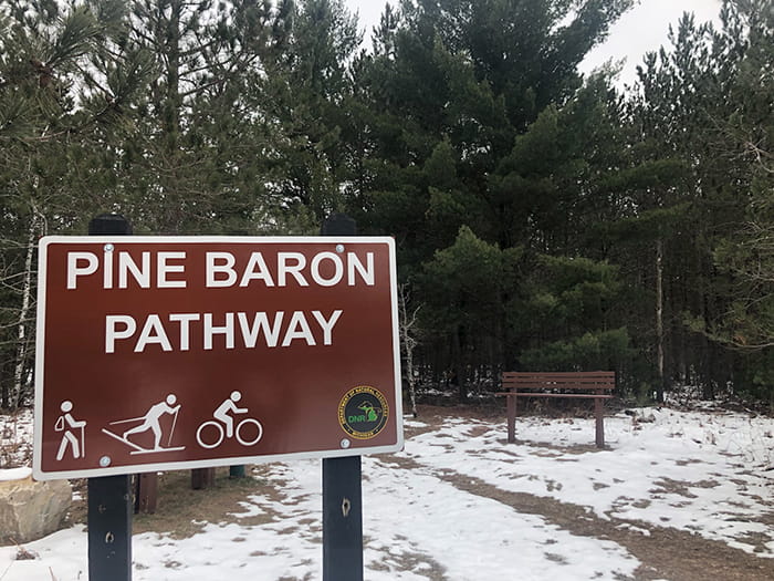 A sign identifying the trailhead of the Pine Baron Pathway