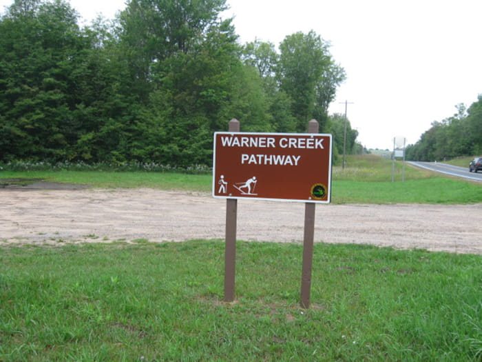 A sign identifying the trailhead of the Warner Creek Pathway