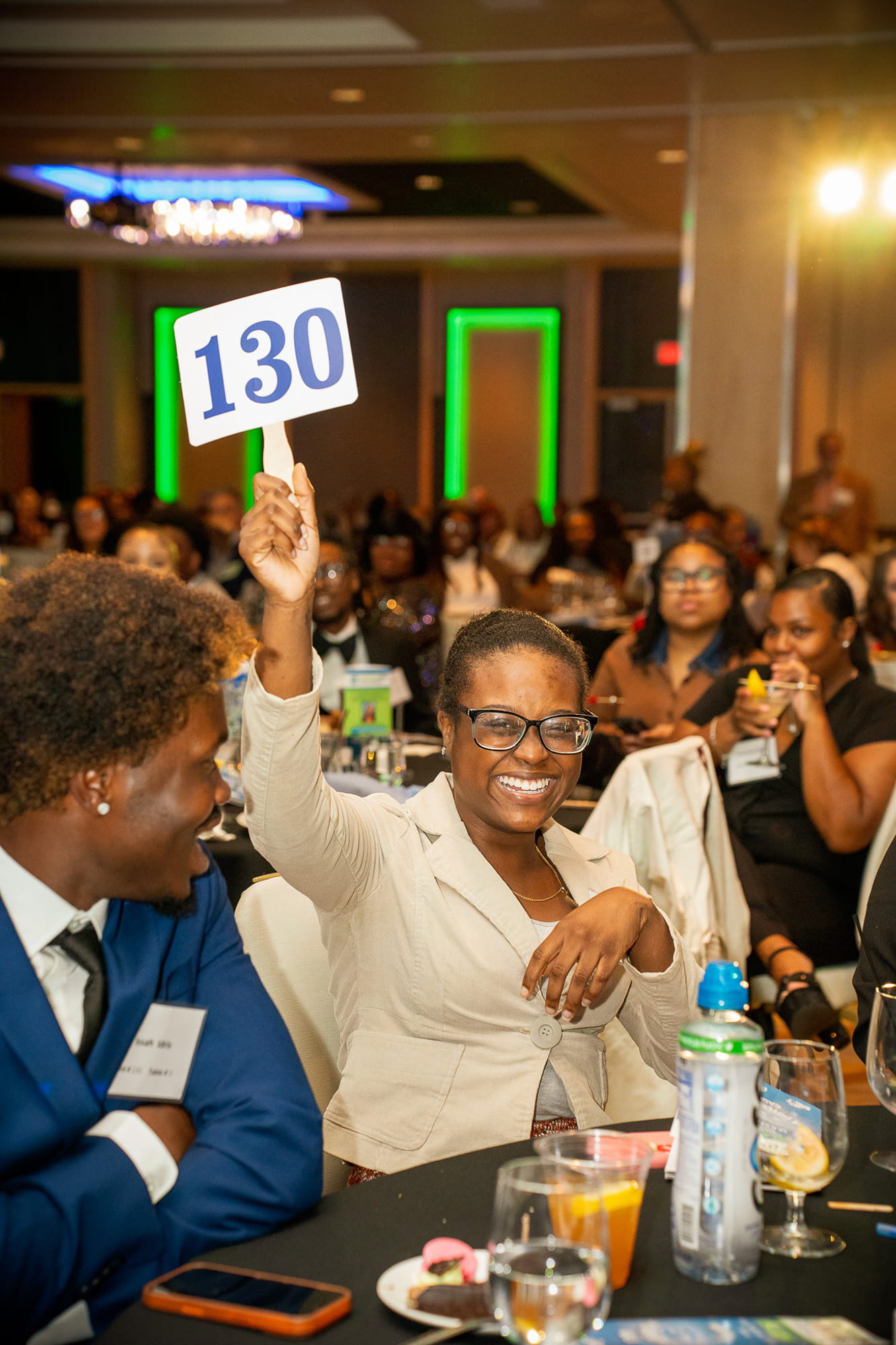 Gala members raising their paddle to raise funds for foster students attending college