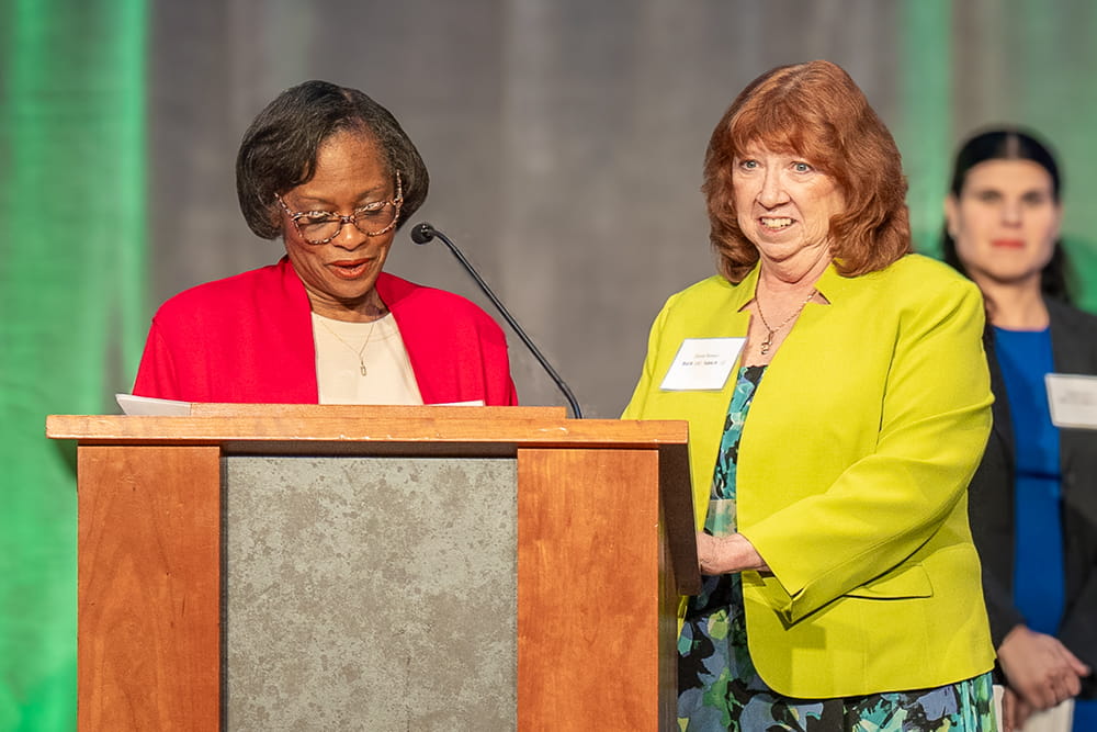 Robin Lott and Diane Brewer at the podium at the Fostering Futures Scholarship Making a Difference Gala