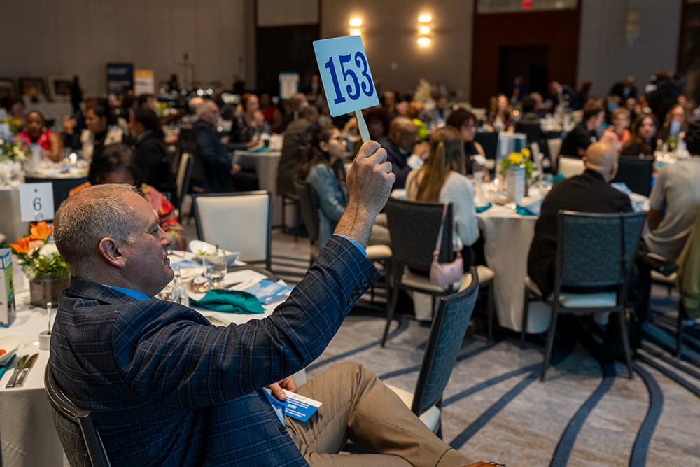 A Gala attendee raises his paddle to raise money for Foster Students in Michigan