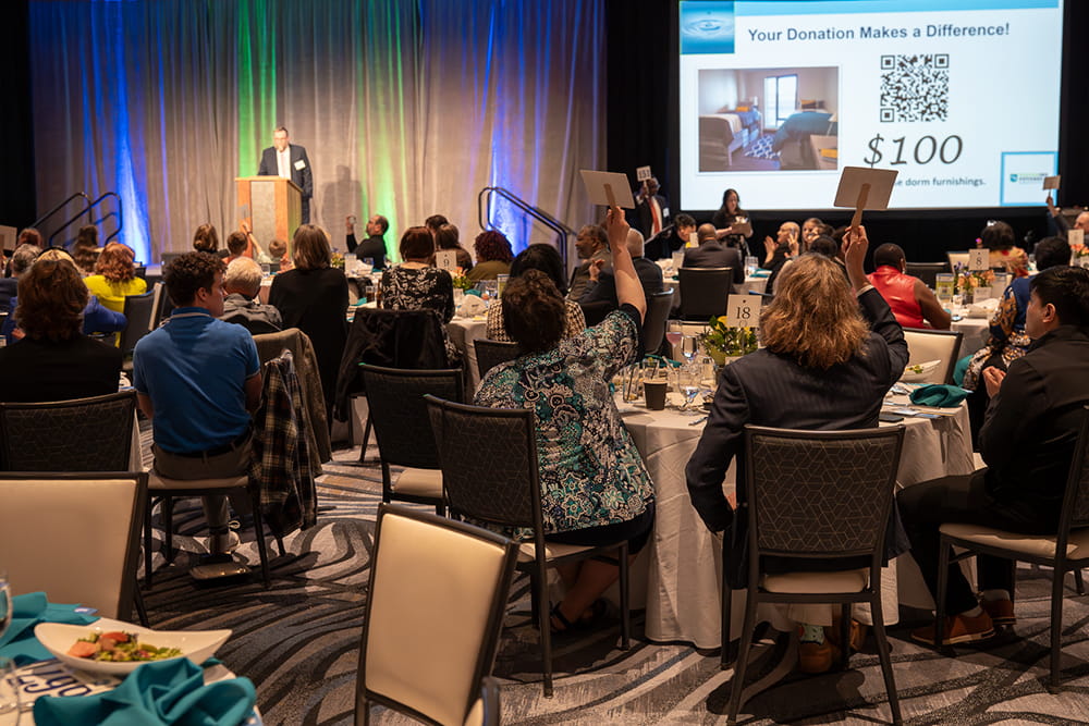 Gala attendees raise their paddles to raise money for Foster Students in Michigan