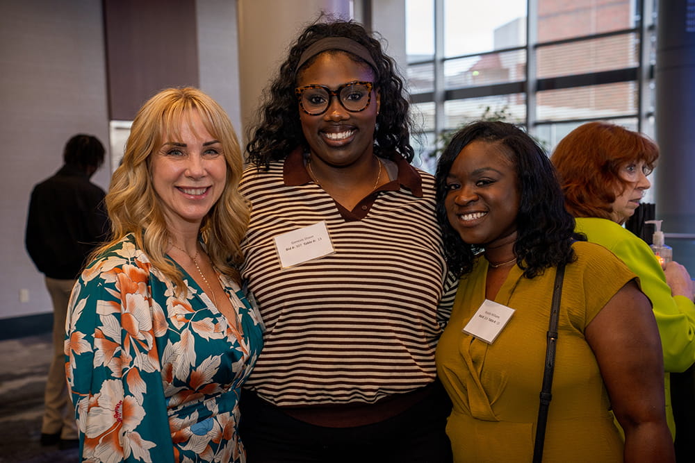 Three women smile for the camera