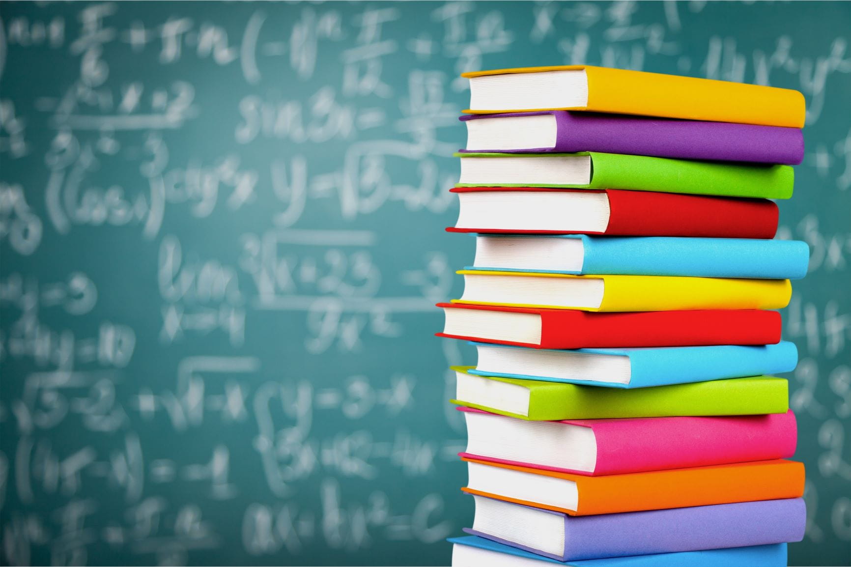 stack of books in front of chalk board