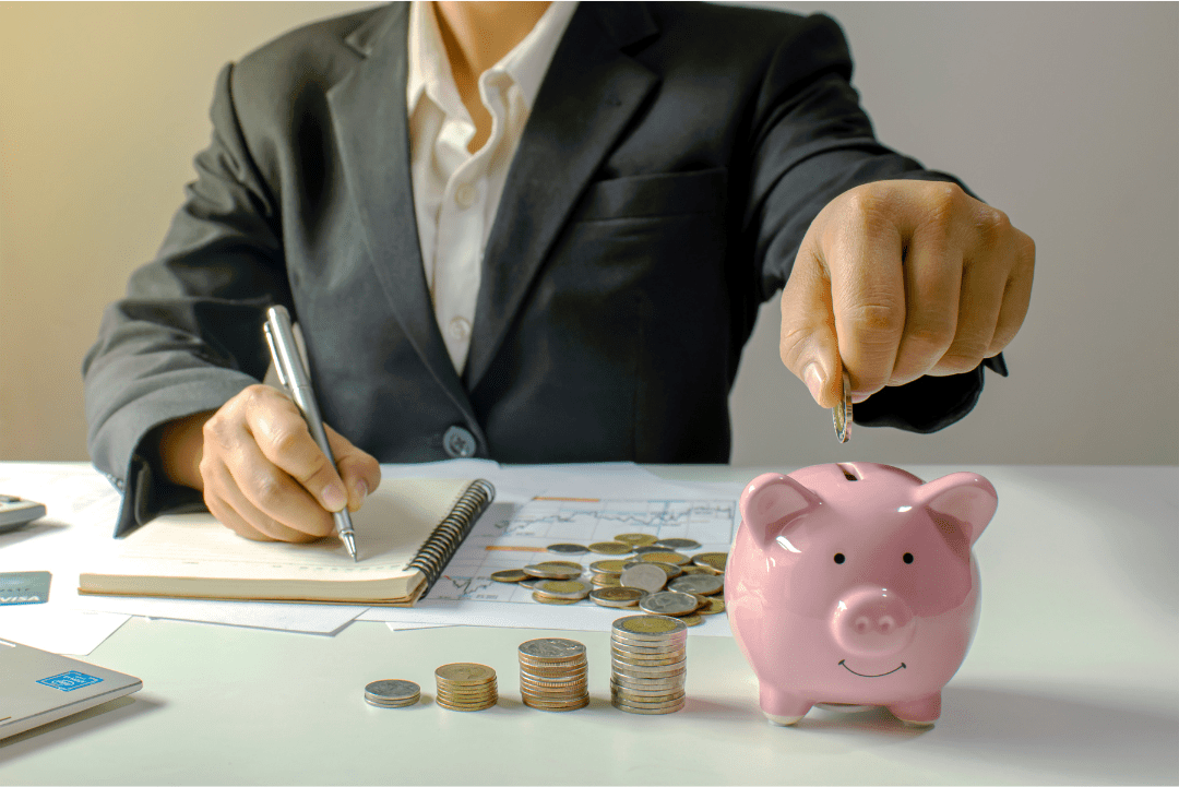 person sitting at a table with stacks of coins