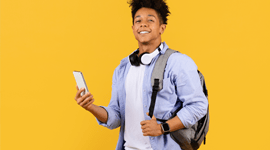 Photo of a male college student wearing a backpack and holding a phone
